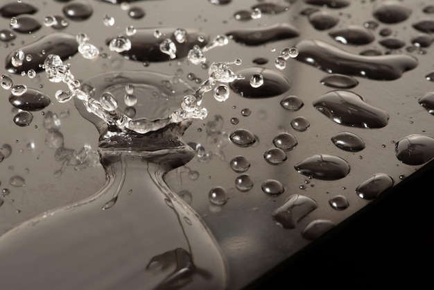 Macro splash macro foto de uma gota de água caindo em um foco seletivo de superfície reflexiva