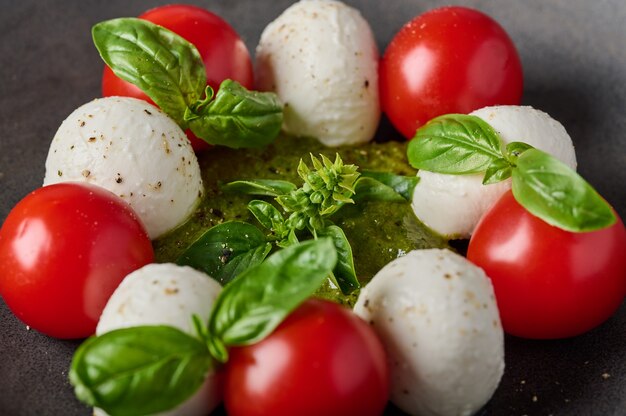 Macro view italiana caprese salada com tomate pesto, manjericão e queijo mussarela com foco seletivo