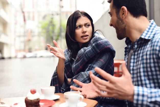 Mad Marriage Partners discutiendo en un café al aire libre.