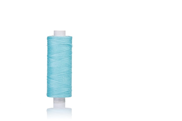Una madeja de hilos de macro de color azul sobre un fondo blanco.