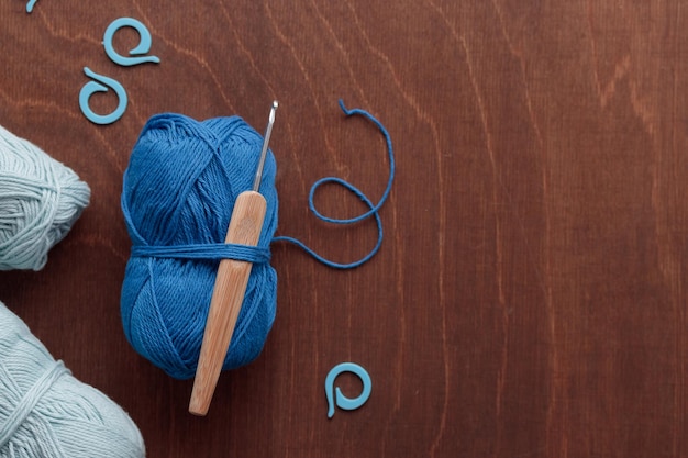 Madejas de hilo de algodón azul para ganchillo hecho a mano sobre un fondo de madera oscura