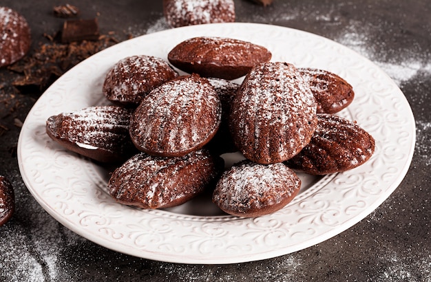 Madeleines de chocolate caseros en mesa oscura