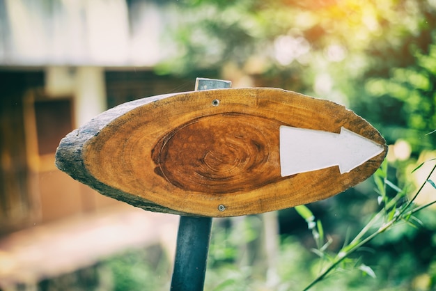 Madera en blanco para escribir un texto y punto de direcciones de flecha