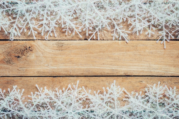 Madera marrón de fondo de Navidad y copos de nieve con el espacio.