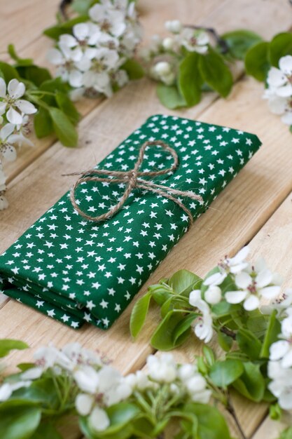 Foto madera natural con flores blancas de árboles frutales y servilleta verde con estrellas