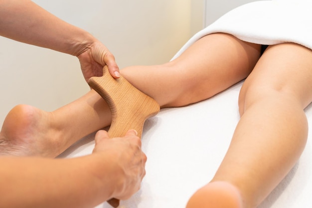 Madero-Therapie Anti-Cellulite-Massage der weiblichen Waden in einem Wellness-Center. Foto in hoher Qualität