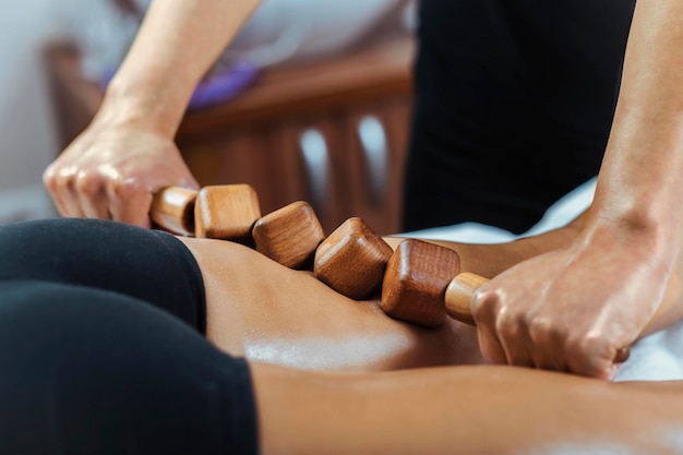 Madero-Therapiemassage mit hölzernem Nudelholz