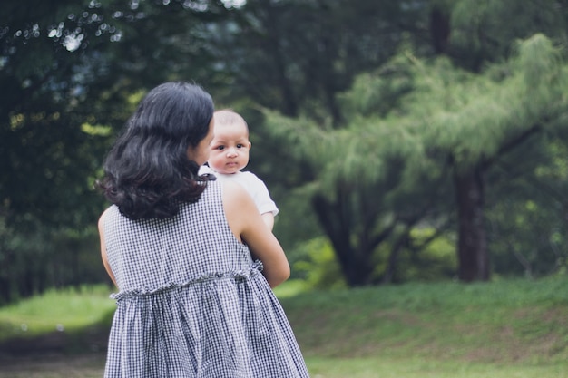 Foto madre abraza a su hijo bebé en el parque