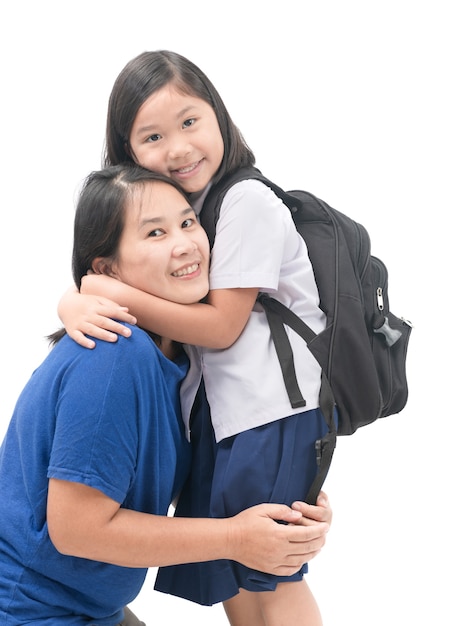 madre abrazando a hija en uniforme estudiante