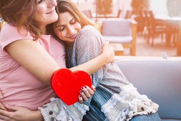 Foto madre abrazando a mujer para el presente