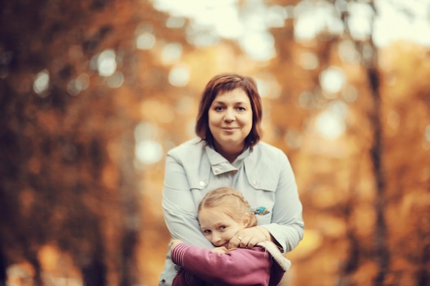 madre abrazando a su hija, Autumn Park