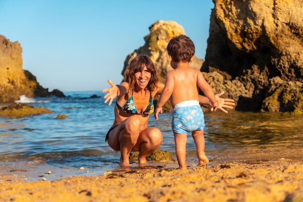 Una madre abrazando a su hijo en la playa de Praia dos Arrifes Algarve beach Albufeira Portugal