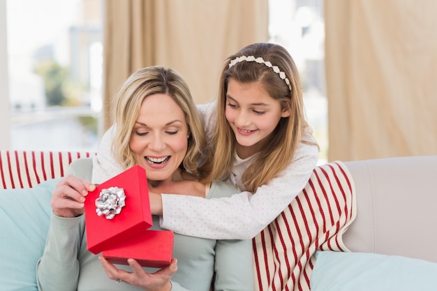 Madre abriendo el regalo de Navidad con la hija