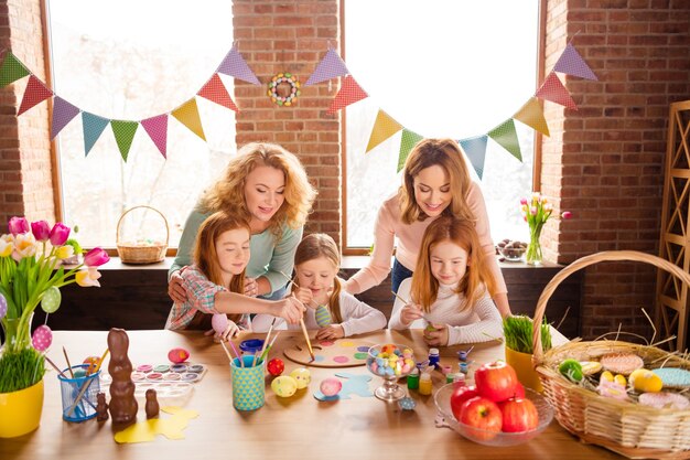 madre y abuela con niños pintando