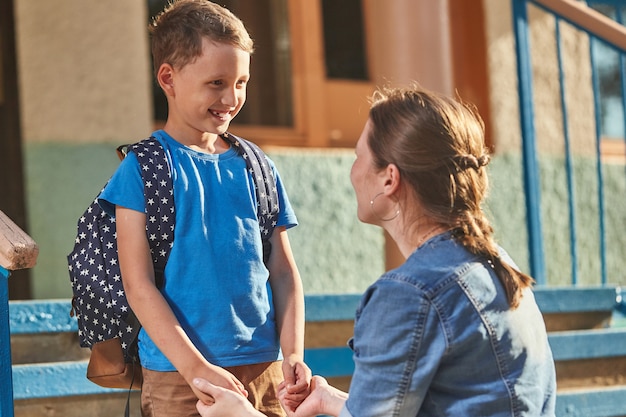 Foto la madre acompaña al niño a la escuela.