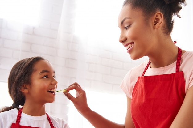 Madre afroamericana está alimentando a su pequeña hija