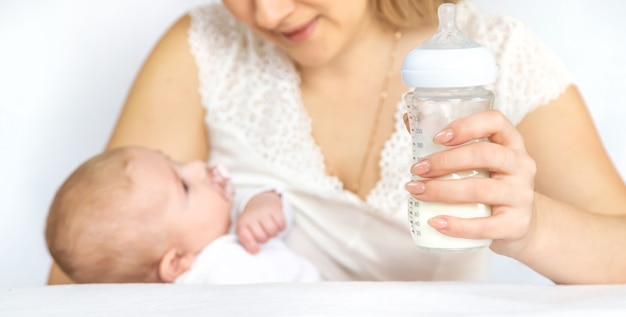 Foto la madre alimenta al bebé con un biberón