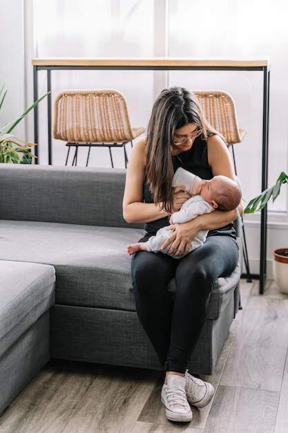 Madre alimentando a su pequeño bebé con un biberón