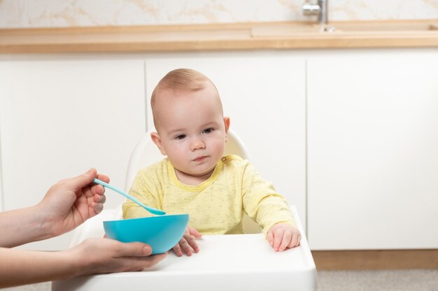 Madre alimentando a su pequeño bebé en casa