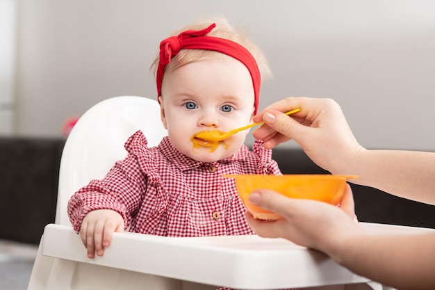 Madre alimentando a su pequeño bebé en casa