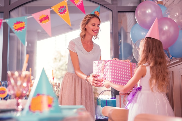 Madre amorosa dando regalo de cumpleaños a su hijo