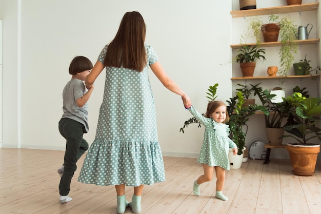 Madre amorosa juega con niños en el interior