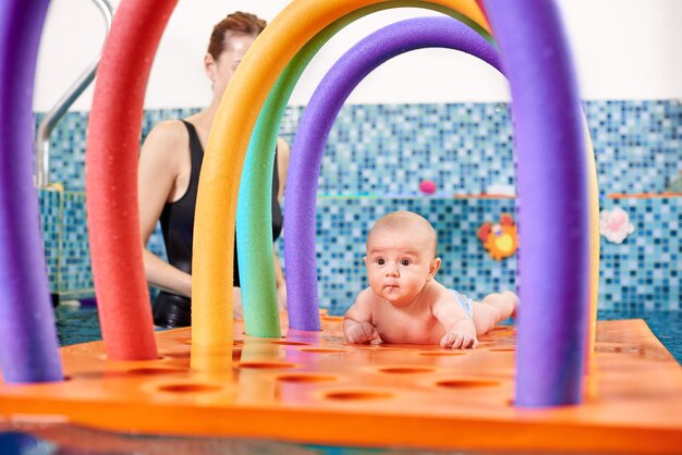 Madre amorosa pasando tiempo con un hijo lindo en la piscina