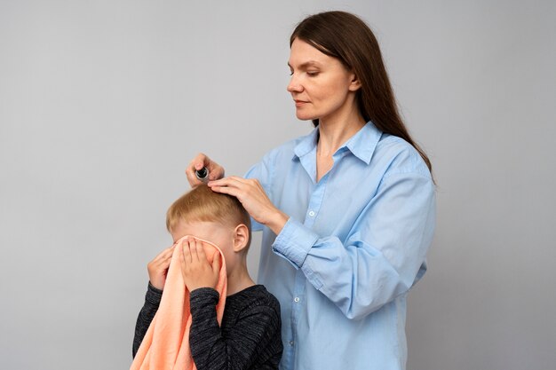 Foto madre aplicando tratamiento para piojos plano medio