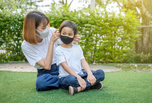 Madre asiática y su hijo con máscaras protectoras