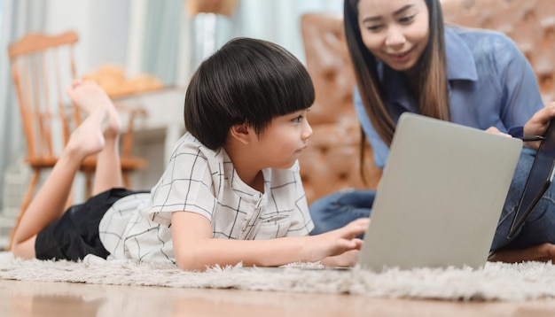 Madre asiática trabaja en casa junto con su hijo. Mamá enseña a niño para la educación de aprendizaje en línea. Nuevo estilo de vida normal y actividad familiar.