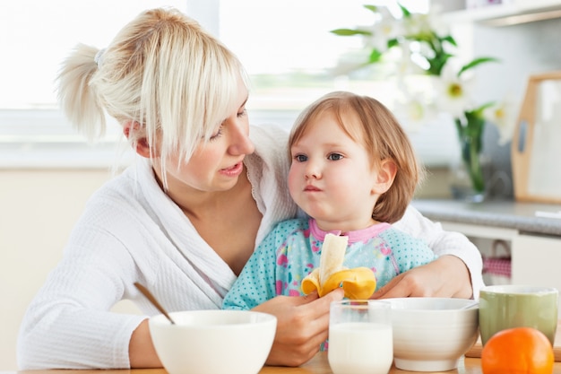 Madre atractiva desayunando con su hija