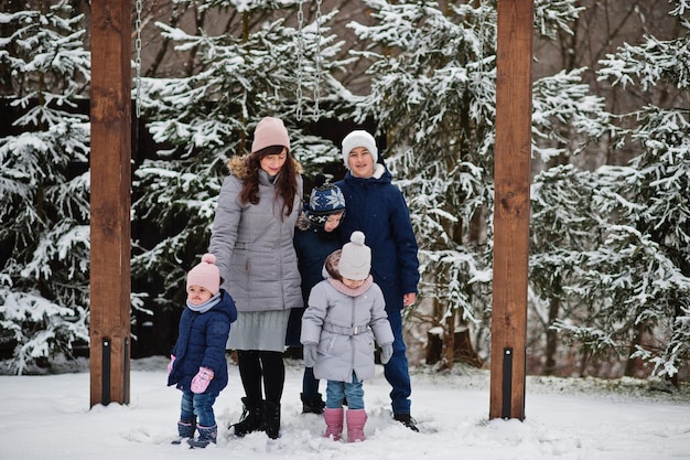 Madre atractiva con sus cuatro hijos en día de invierno