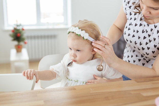 La madre ayuda a poner un implante coclear para su pequeña hija sorda Audífono y concepto de sordera