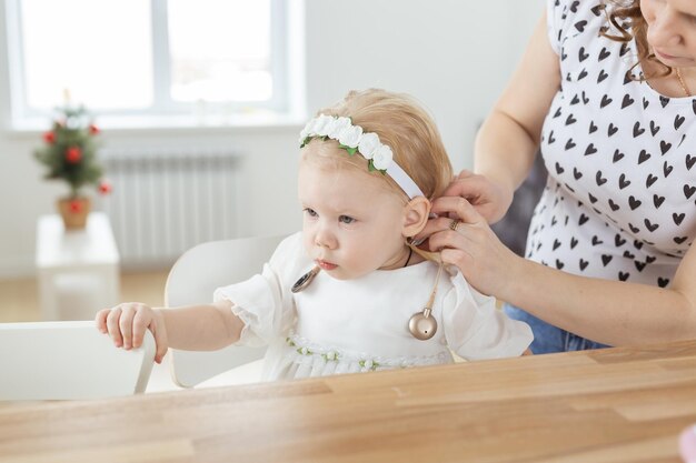 La madre ayuda a poner un implante coclear para su pequeña hija sorda audífonos y sordera