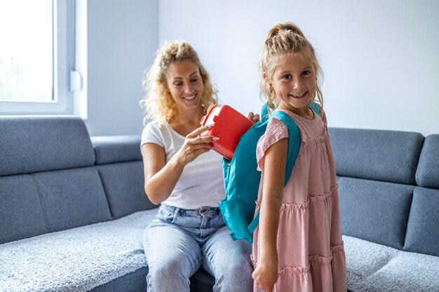 La madre ayuda a su hija a prepararse para la primera clase.