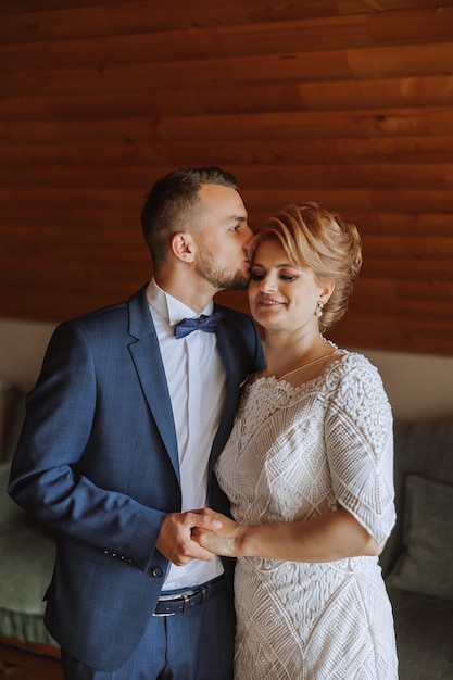 Foto una madre ayuda a su hijo adulto a prepararse para la ceremonia de la boda un momento emocional y conmovedor en una boda una madre abraza a su hijo