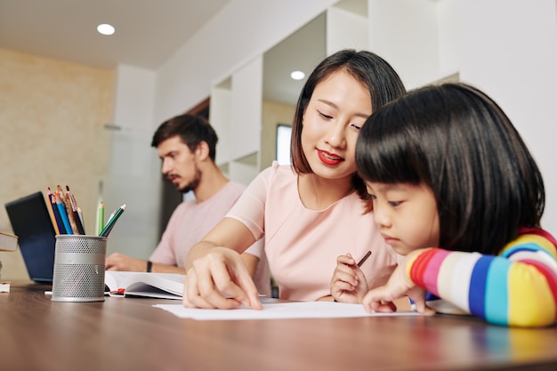 Madre ayudando a su hija con el dibujo