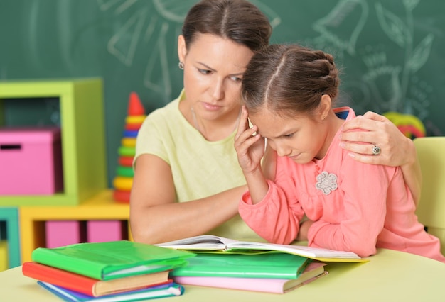 Madre ayudando a su hija a hacer la tarea