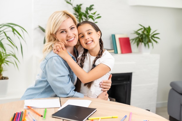 Una madre ayudando a su hija con la tarea.