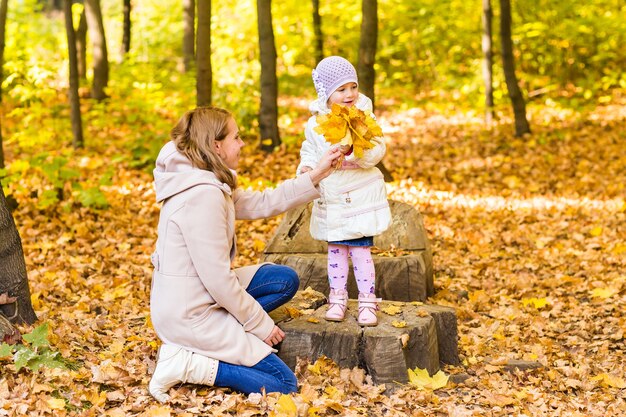 Madre con bebé al aire libre en la naturaleza de otoño