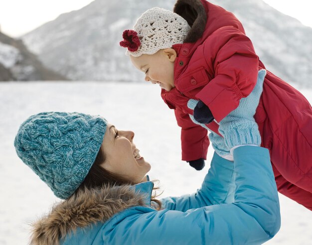 Una madre y un bebé al aire libre en la nieve.