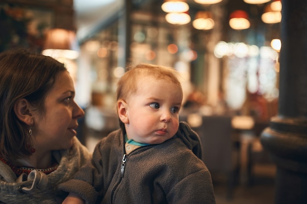 Madre con bebé en café esperando orden