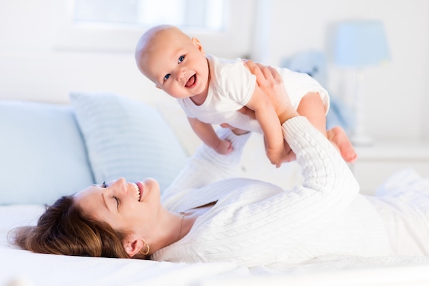 Madre y bebé en una cama blanca