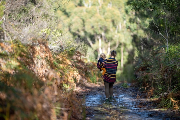 madre y bebé caminando en el bosque en primavera