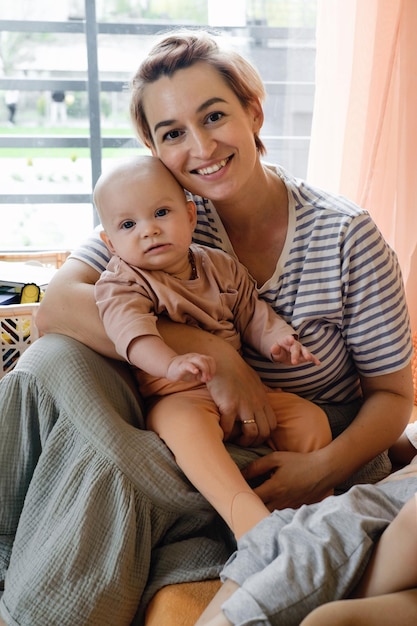 Foto madre con bebé en la habitación de los niños por encima de la ventana retrato de madre y bebé en casa familia moderna