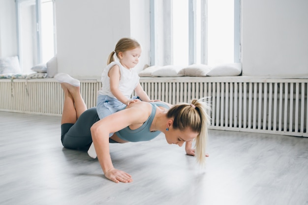 Madre y bebé hacen ejercicios juntos en el gimnasio.