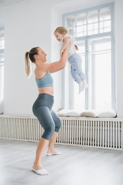 Madre y bebé hacen ejercicios juntos en el gimnasio.