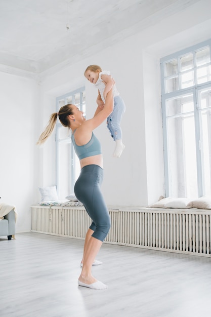 Madre y bebé hacen ejercicios juntos en el gimnasio.