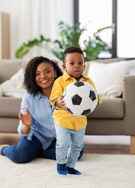 Foto madre y bebé jugando al fútbol en casa