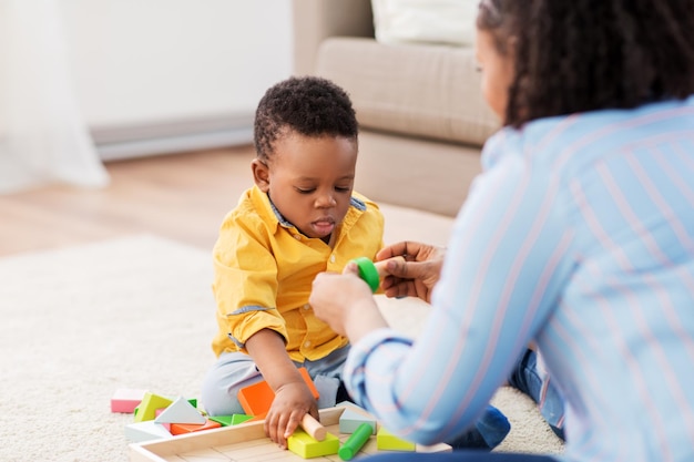 Foto madre y bebé jugando con bloques de juguete en casa